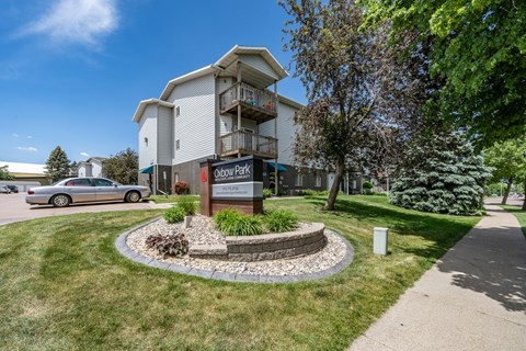 A building with a sign that says "Cobblestone Park" in front of it.