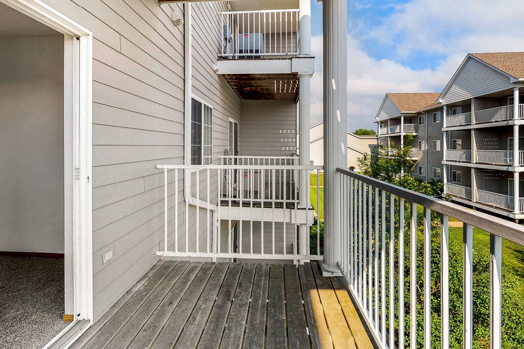 the deck has a view of the condo building and the yard
