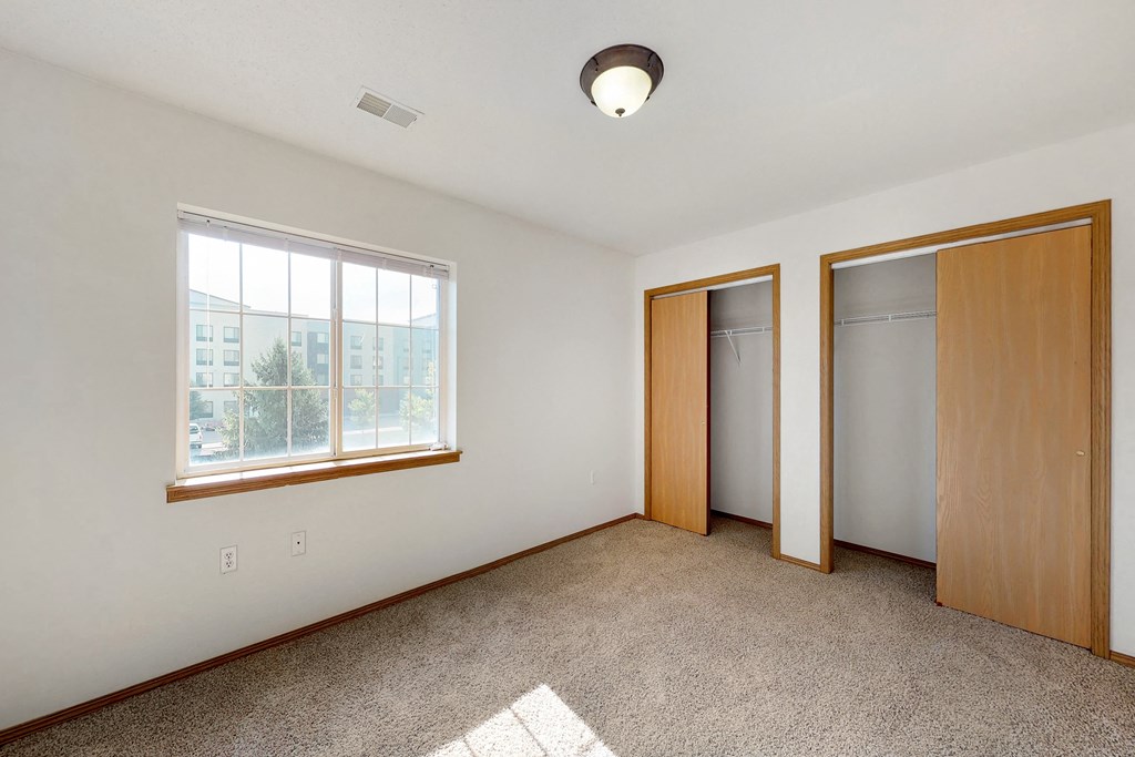 an empty living room with two doors and a window
