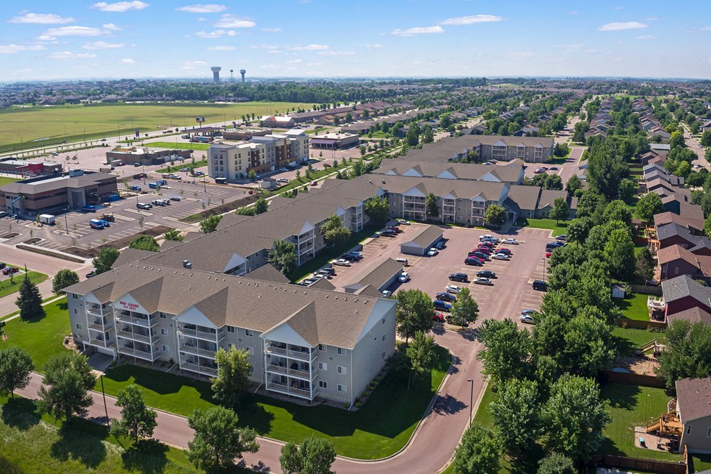 an aerial view of an apartment complex with cars parked in a parking lot