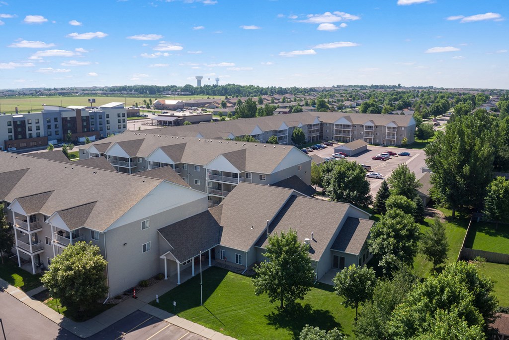 an aerial view of a building complex with green grass and trees