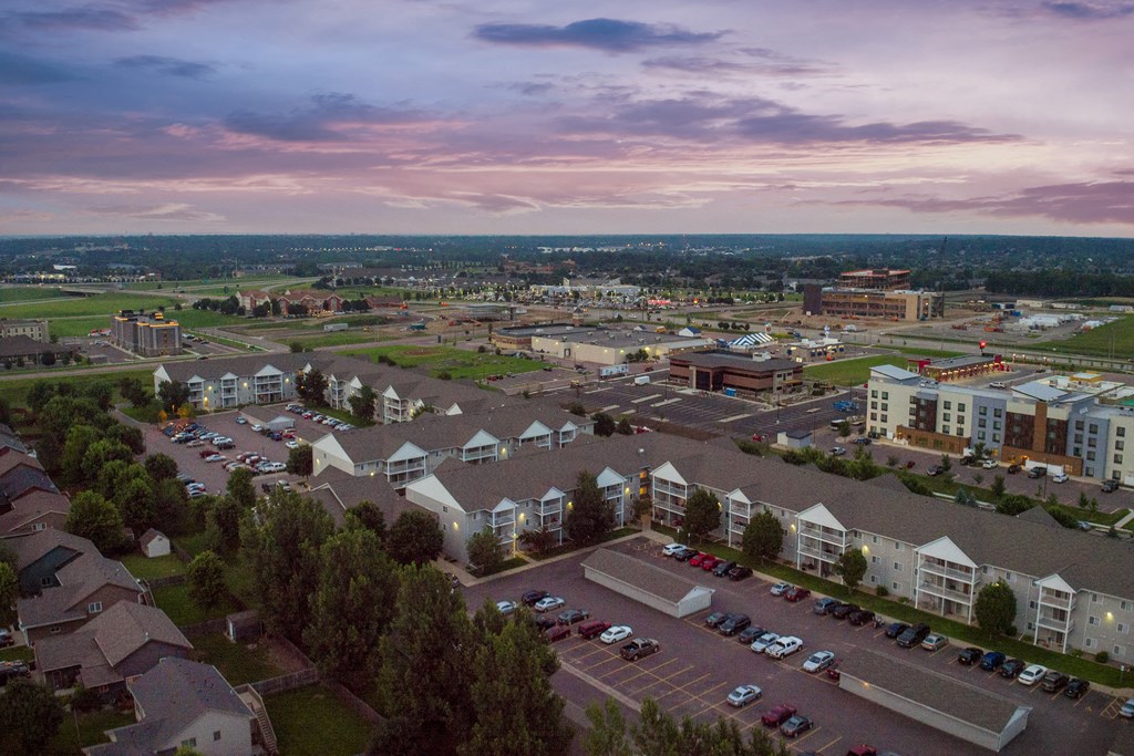 an aerial view of an apartment complex with cars parked in a parking lot