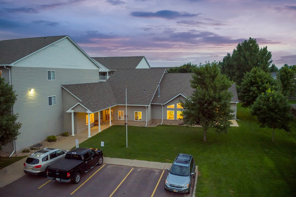 an aerial view of a house with cars parked in a parking lot