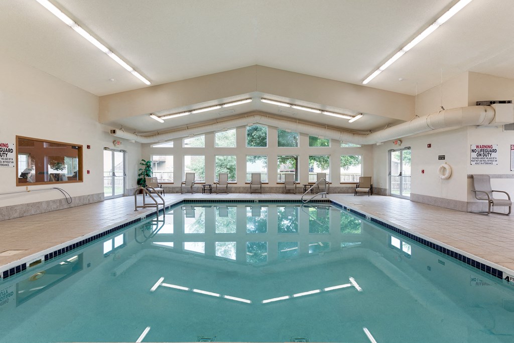 the indoor pool of a hotel with a view of the windows