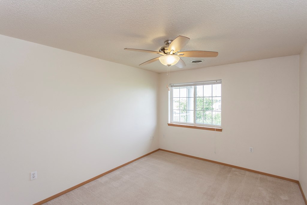 the living room of a home with a ceiling fan and a window