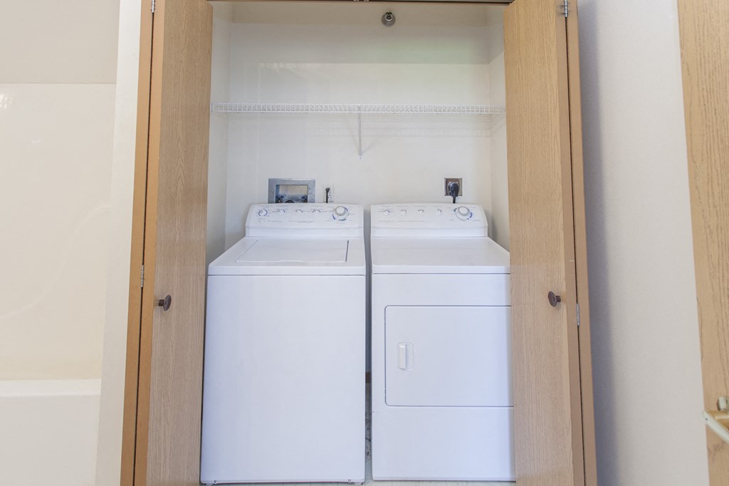 an empty laundry room with two washes and a dryer