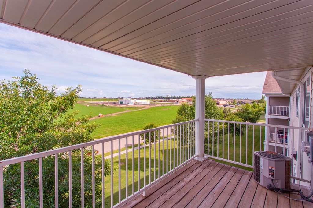 a view from the deck of a home with a view of a field