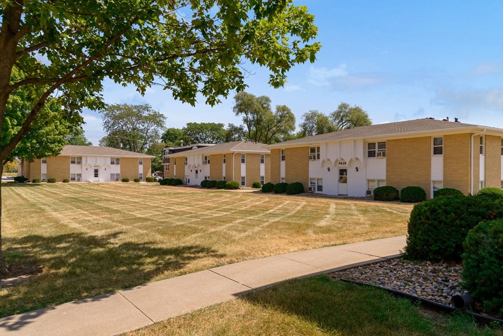 a row of yellow and white houses with a sidewalk