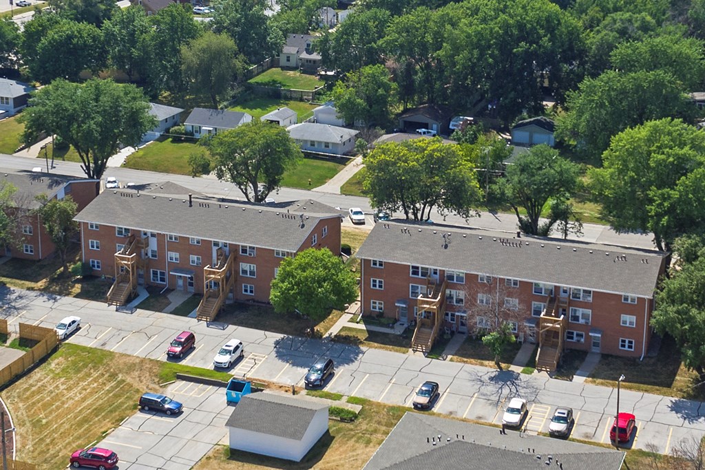 an aerial view of an apartment building and parking lot