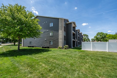 A modern building with a white fence in front.