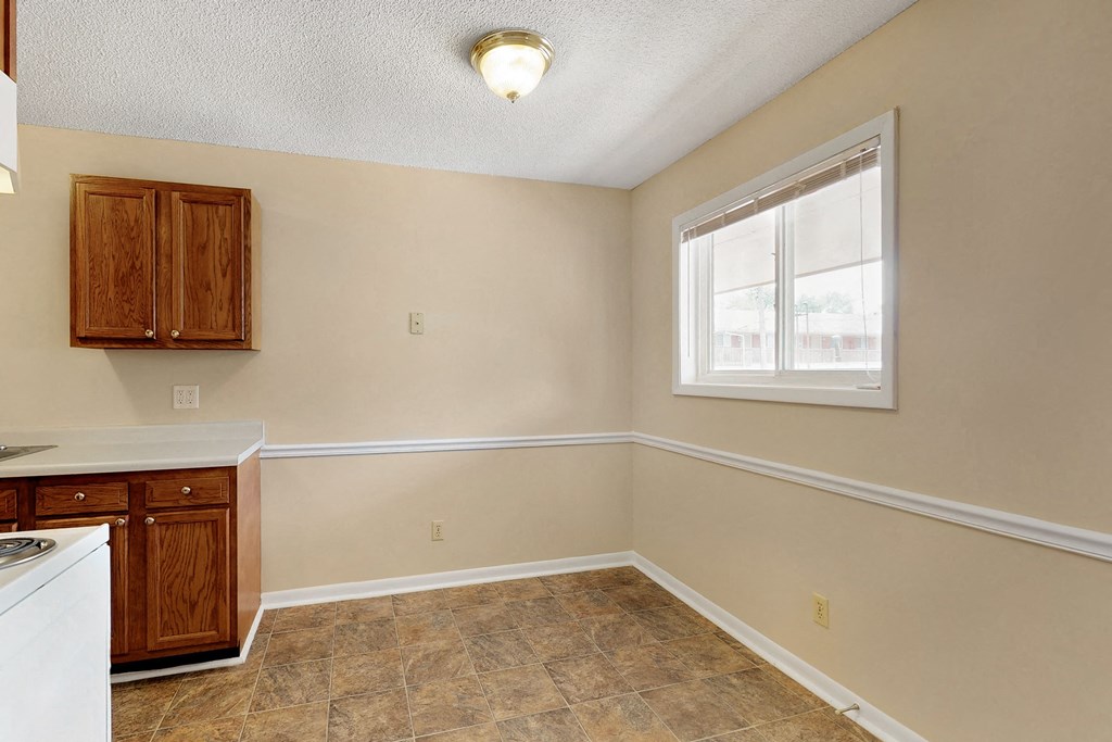 an empty kitchen with a window and a counter top