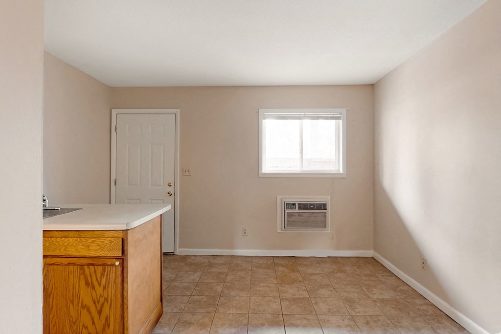an empty kitchen with an air conditioner and a window