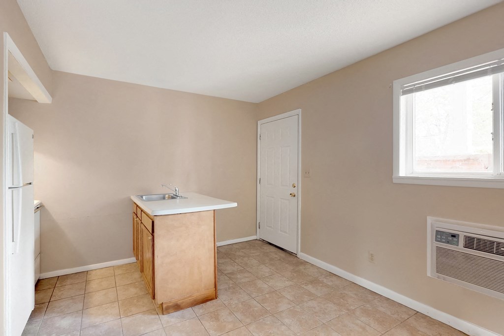 an empty kitchen with a sink and a door