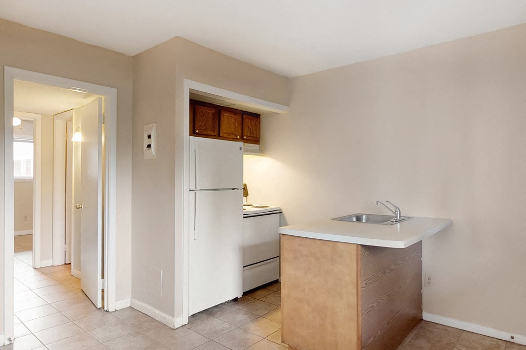 an empty kitchen with a sink and a refrigerator