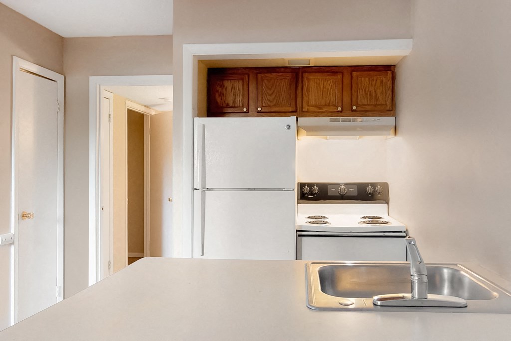 an empty kitchen with a sink and a refrigerator