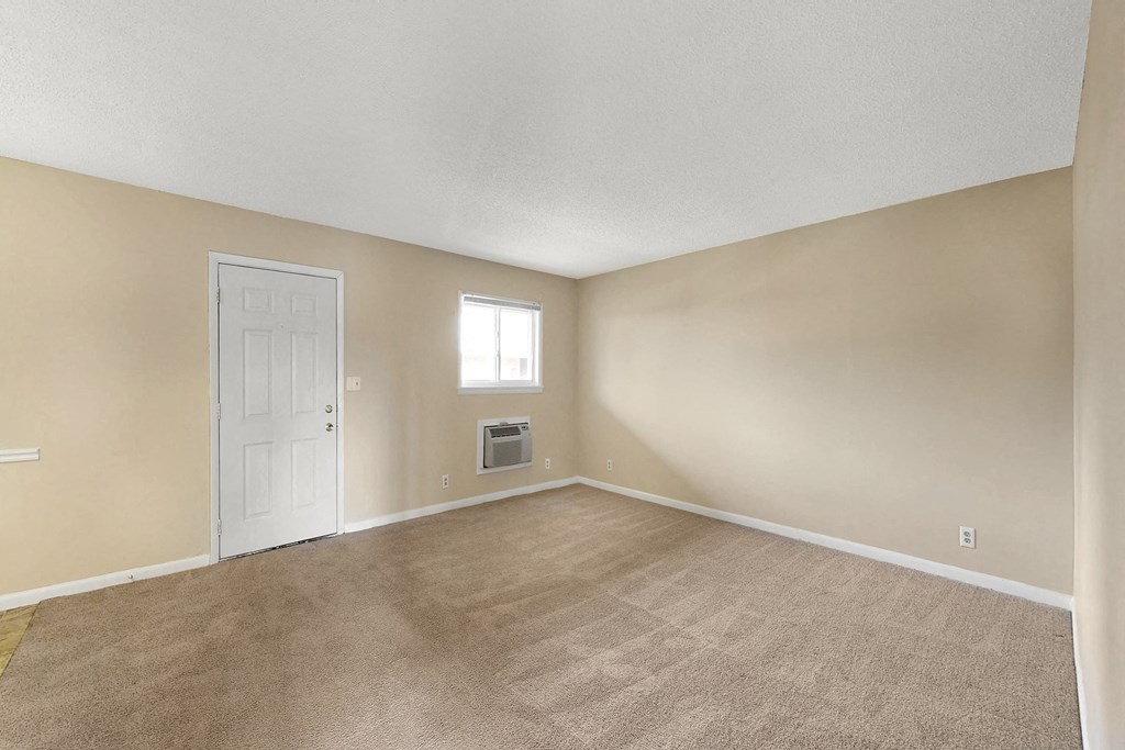 the living room of an empty home with a white door