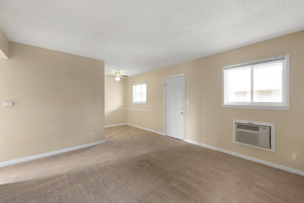 the living room and dining room of an empty house with a door and window