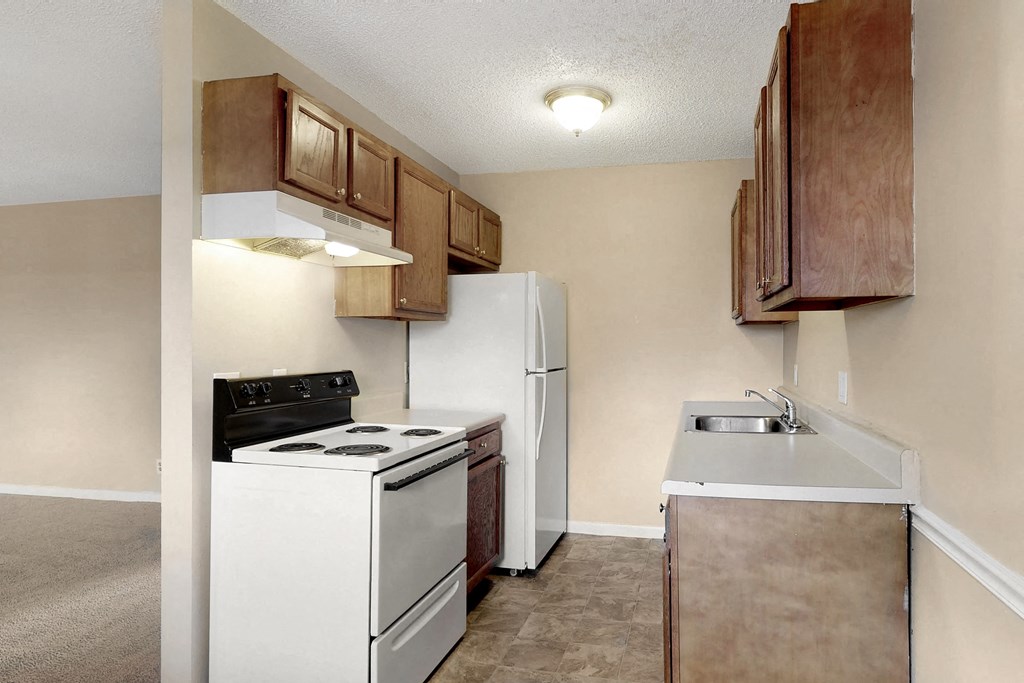 an empty kitchen with a stove refrigerator and sink