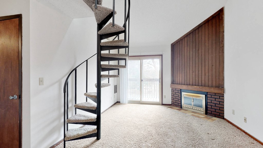 a spiral staircase in a living room with a fireplace