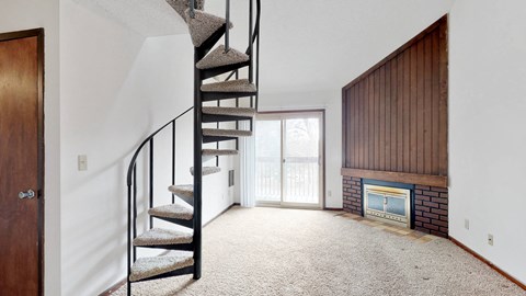 a spiral staircase in a living room with a fireplace
