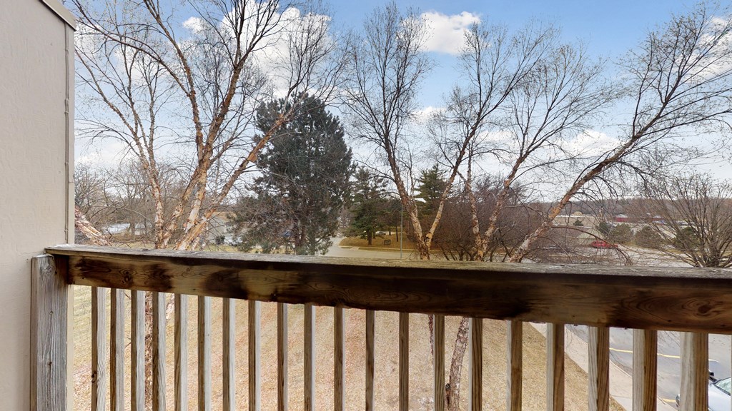 the view from the deck of a house overlooking a yard and trees