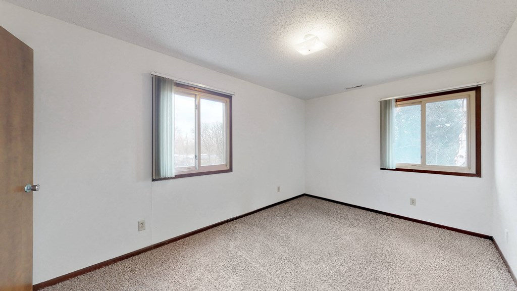 the living room of an empty house with two windows
