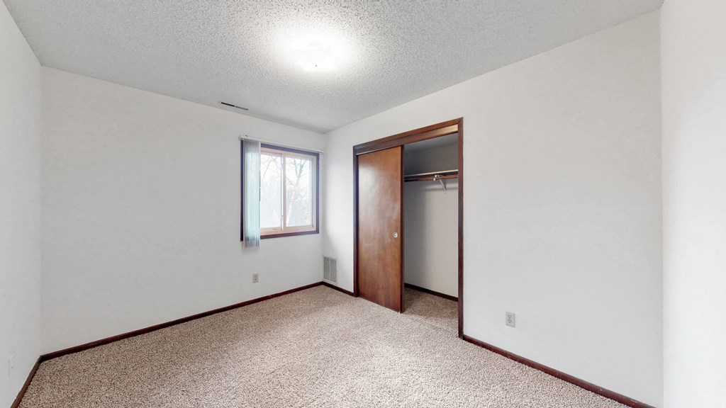 an empty living room with a door to a closet