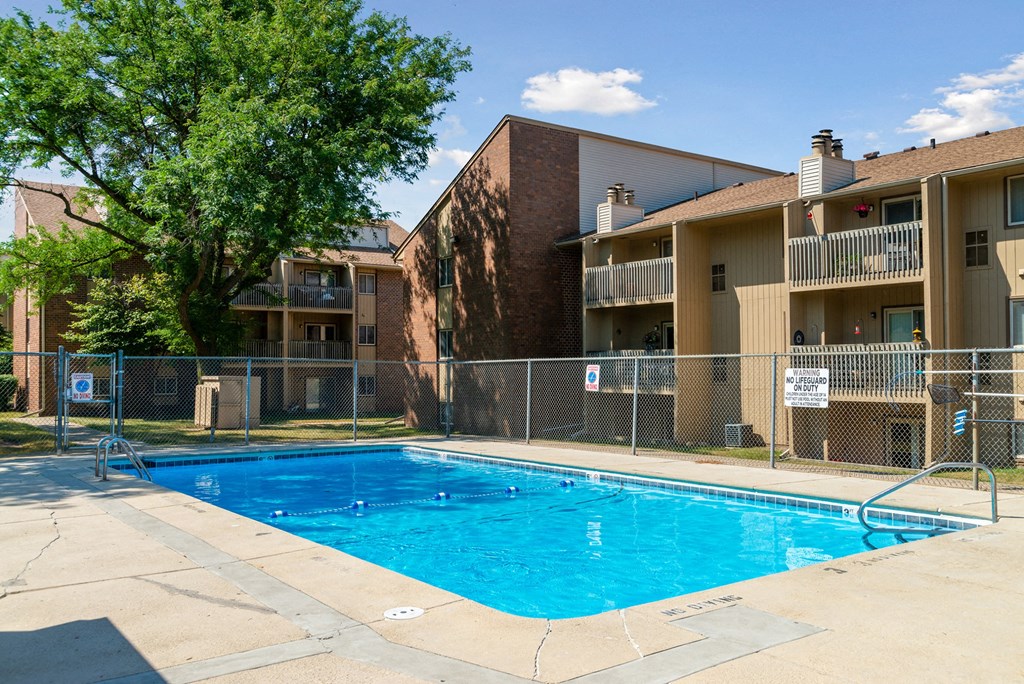 a swimming pool in front of an apartment building