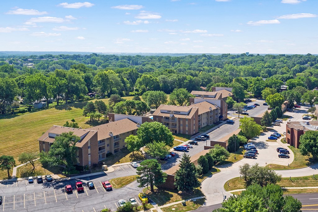 an aerial view of a campus with cars parked in a parking lot