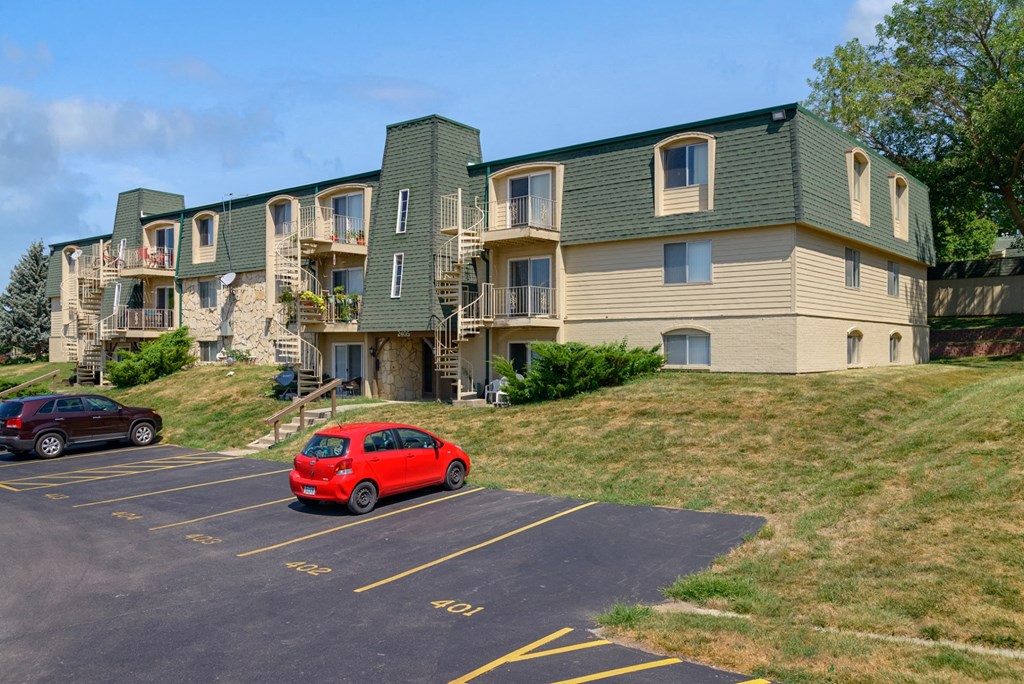 a car parked in a parking lot in front of an apartment building