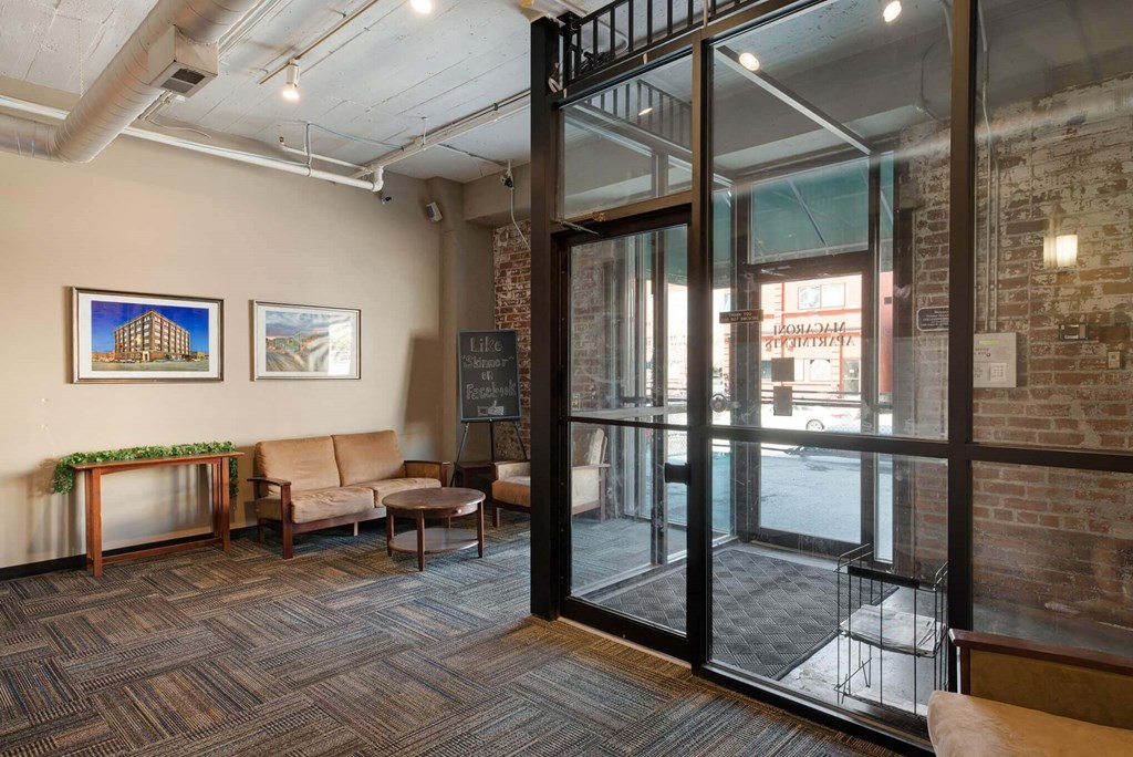 a lobby with seating and a glass door