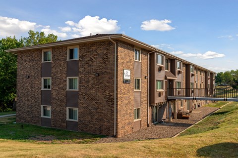a brick apartment building with a balcony and a bridge