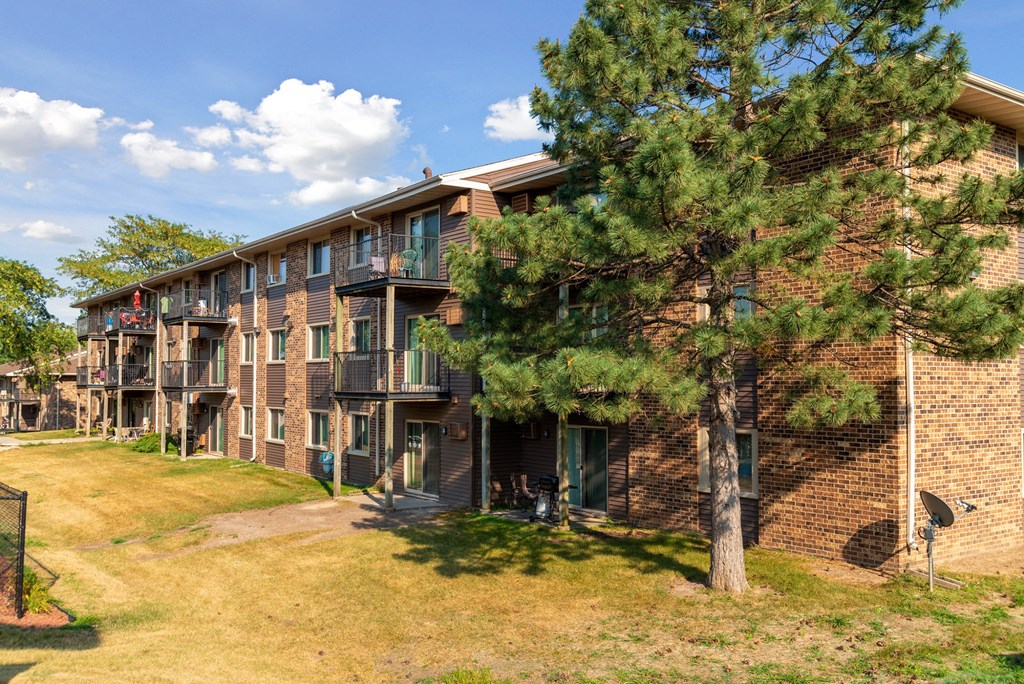 a brick apartment building with trees in front of it