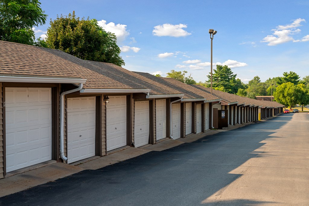a row of garages with white doors and roofs