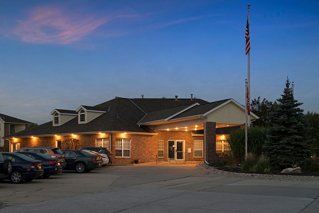 the front of our building at night with cars parked in front