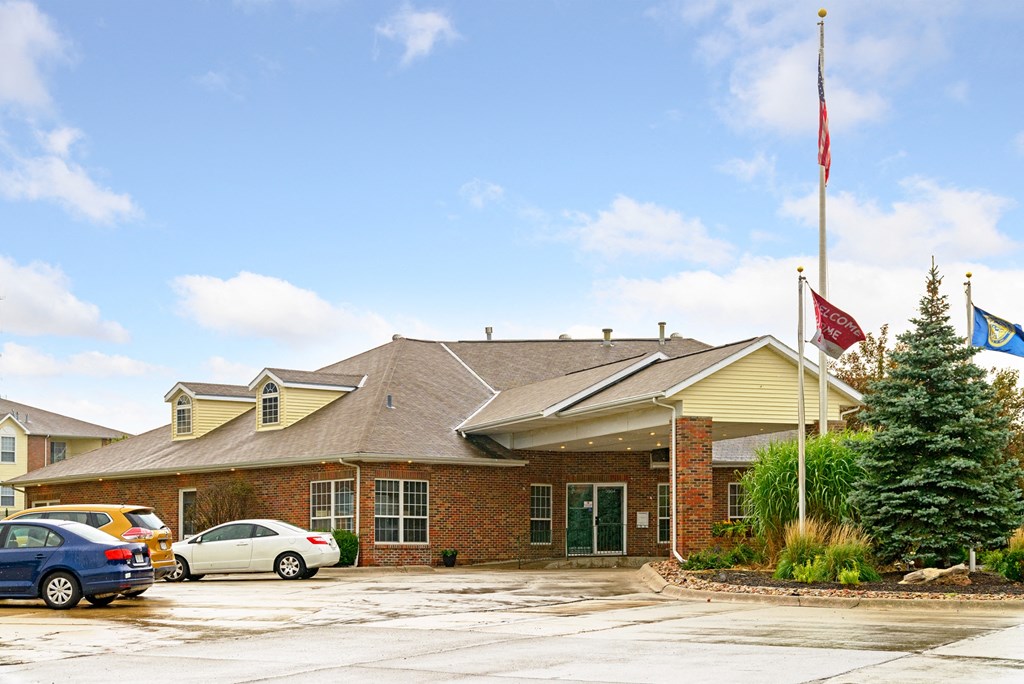 the front of a brick building with cars parked outside