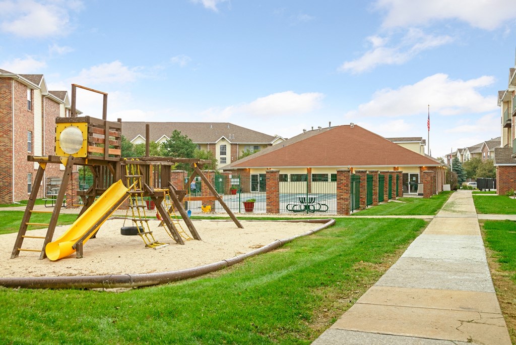 a playground in front of a school with a sidewalk