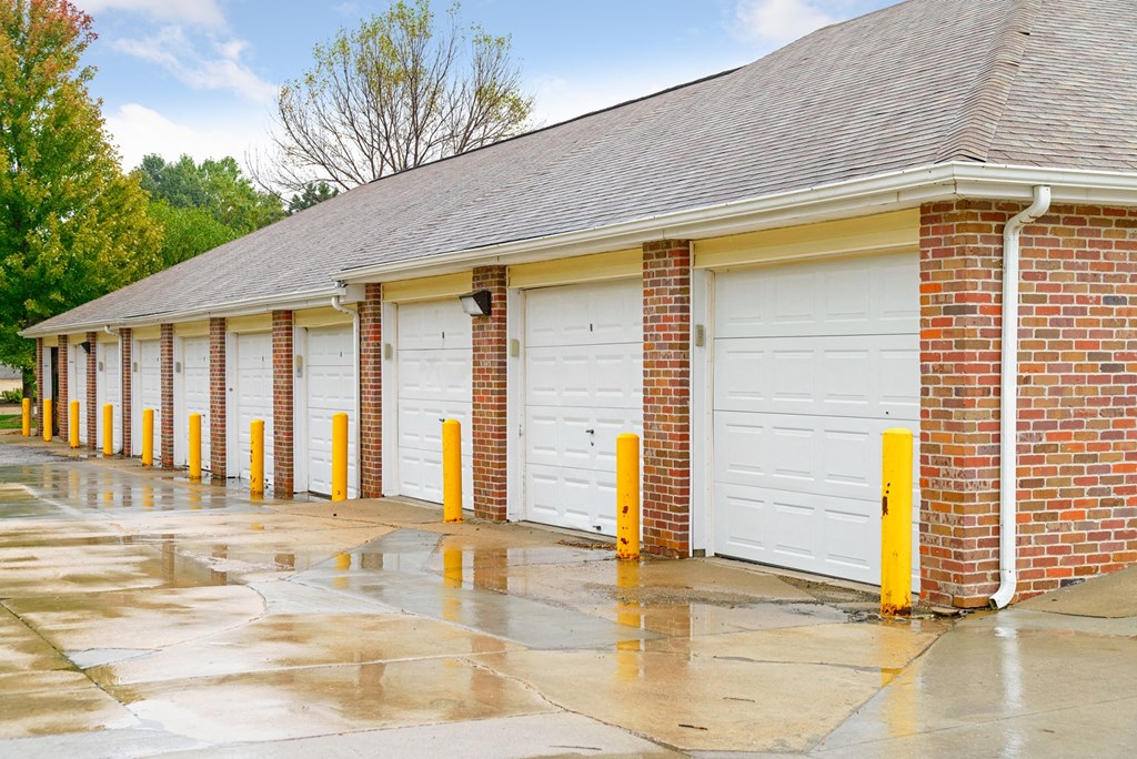 a row of garage doors in front of a brick building