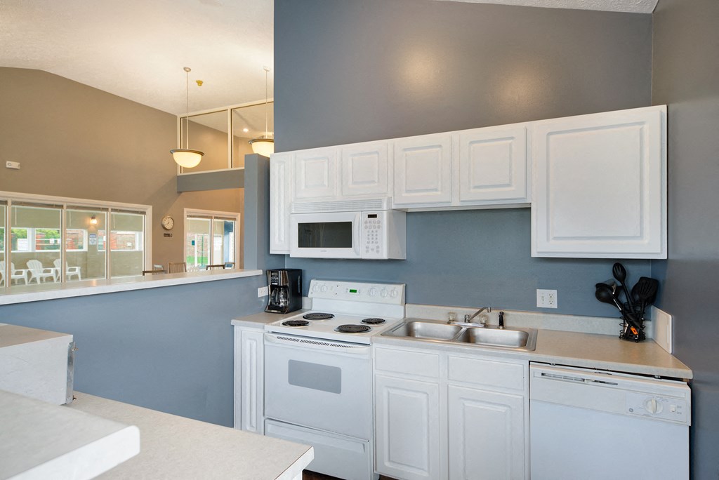 a kitchen with white cabinets and a sink and a stove