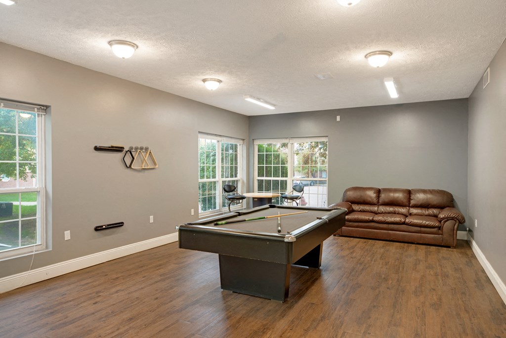 an empty living room with a pool table and a couch