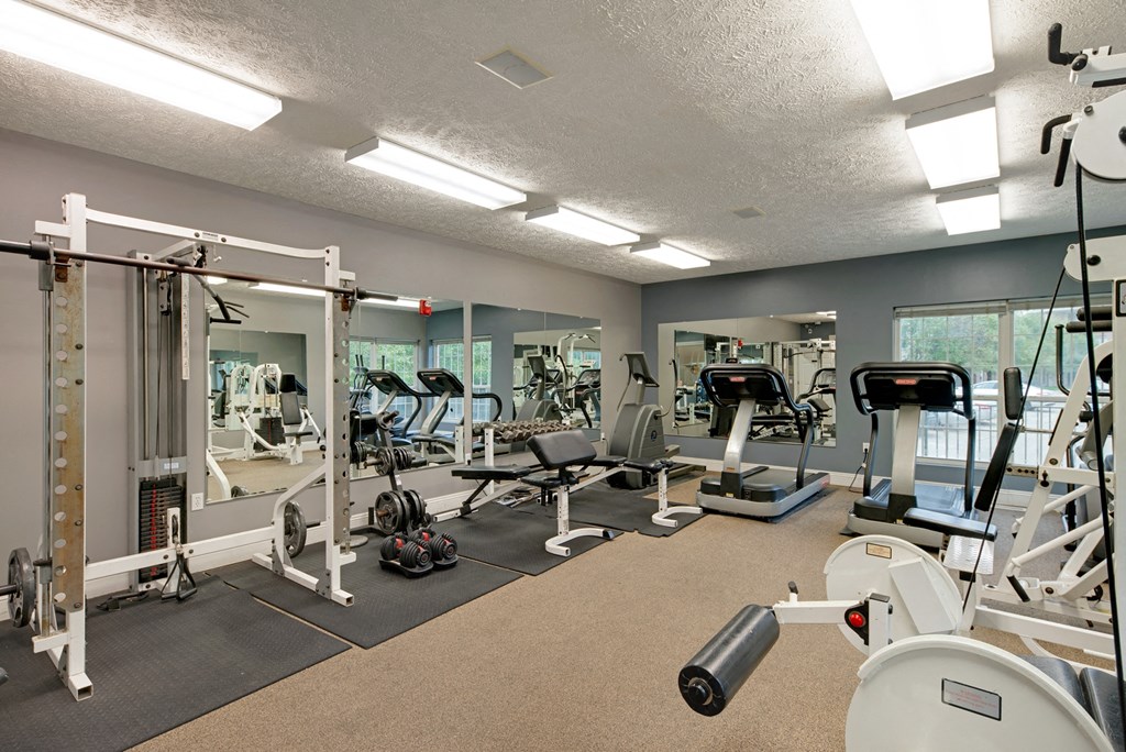 a gym with various machines and weights on the floor