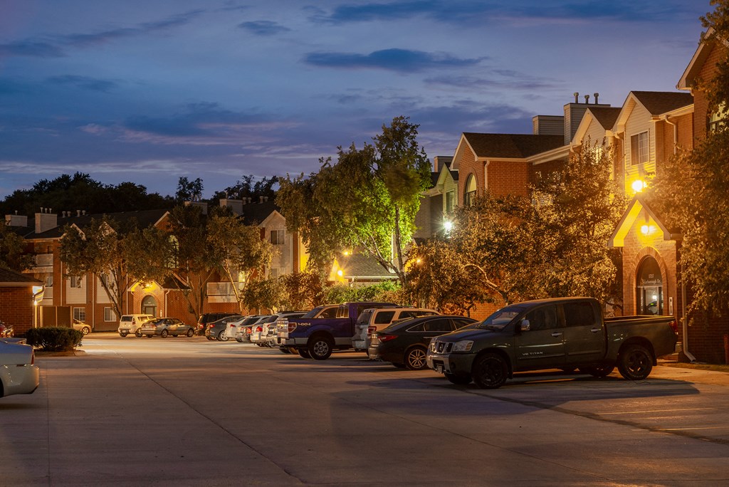 a row of houses on a street at night with cars parked