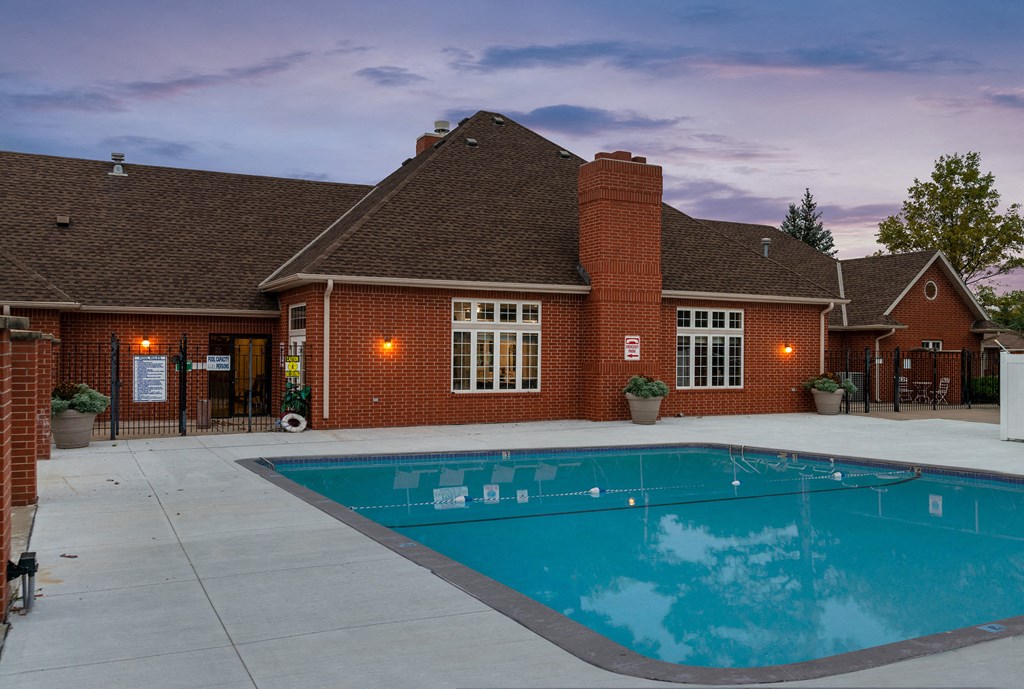a swimming pool in front of a brick house