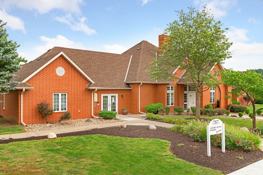 a red brick house with a white sign in front of it