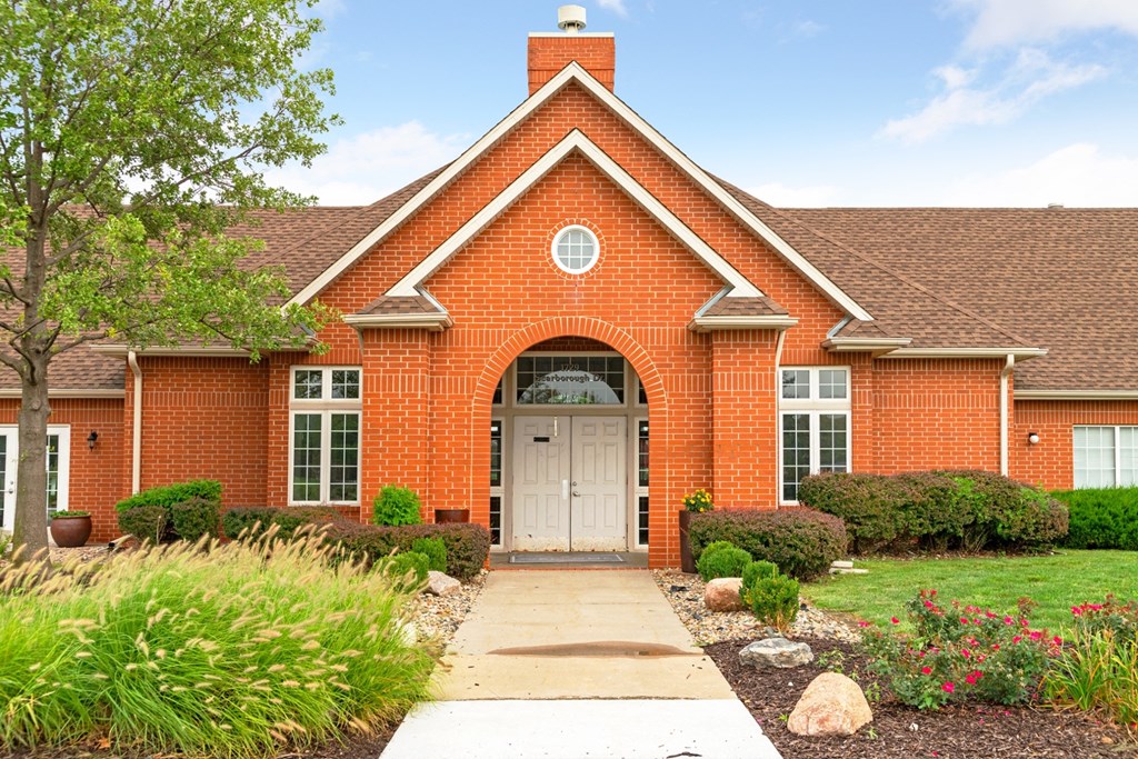 the front of a red brick house with a white door