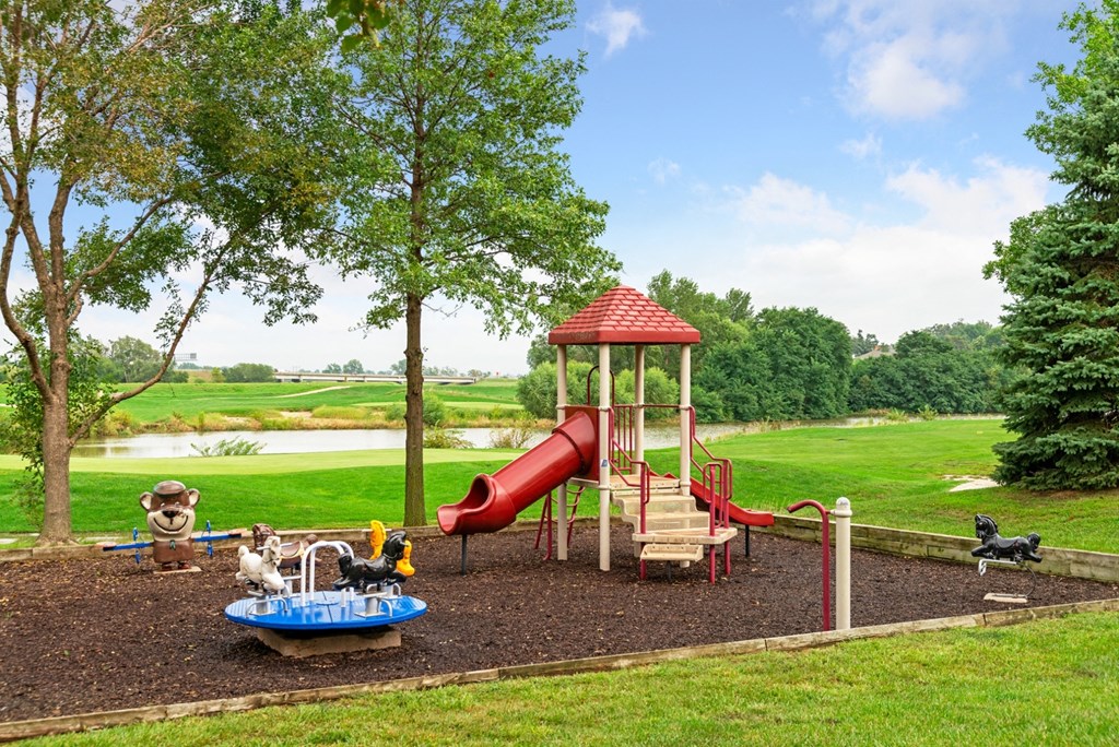 a playground with a red slide in a park
