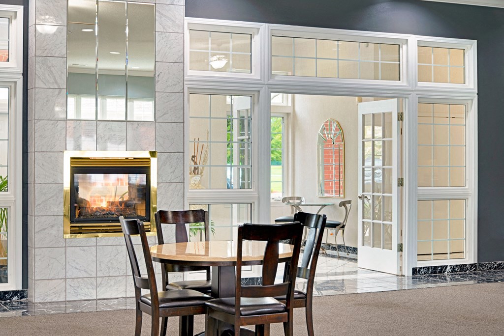 a dining room with a table and chairs in front of a fireplace