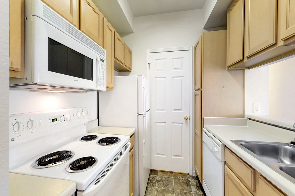 a kitchen with white appliances and wooden cabinets