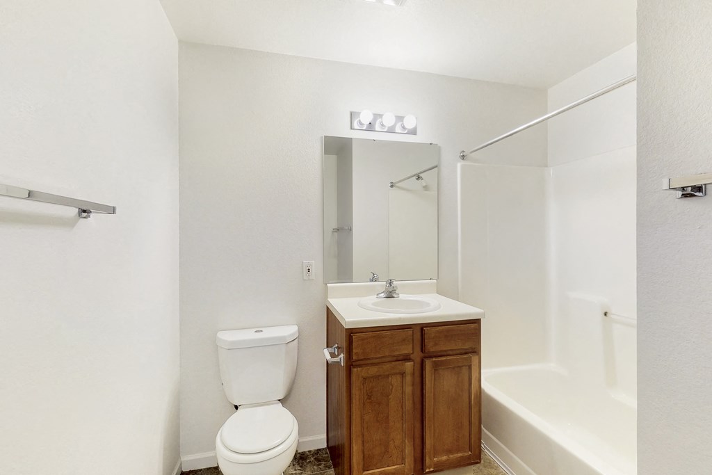 a bathroom with a toilet sink and shower and a mirror