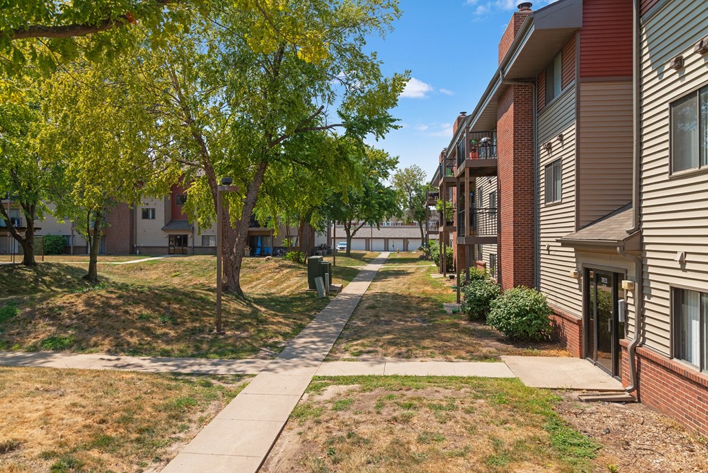 our apartments have a sidewalk and grassy area with trees